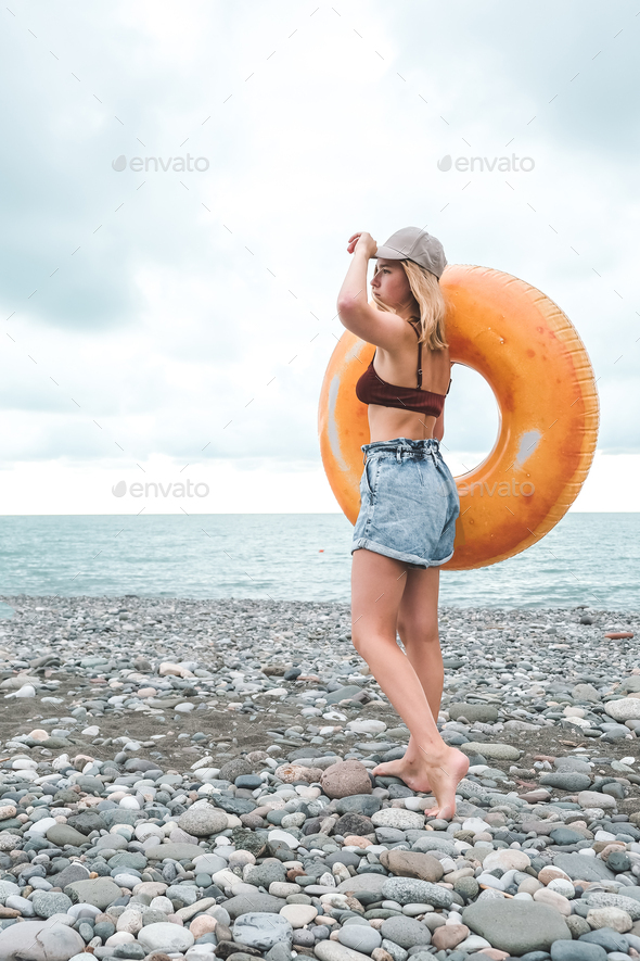 Traveler girl resting on the beach near the sea. Eco travel, taking care of yourself physical and
