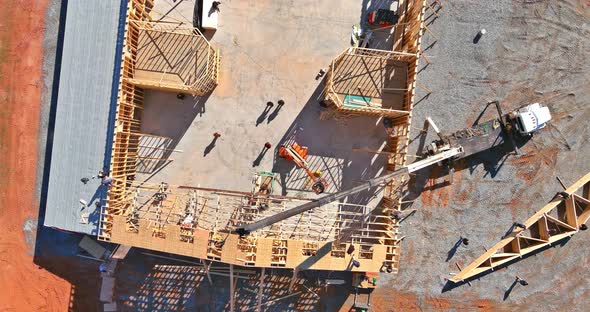 The Wood Roof is Supported By a Crane for the Installation of Roof Truss Beams alt