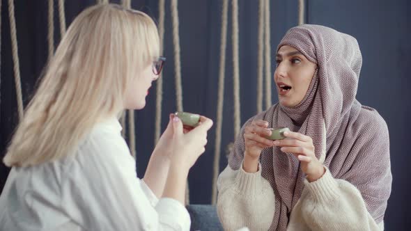 Religious Muslim Woman and Her Female Secular Blonde Friend Are Talking Friendly alt