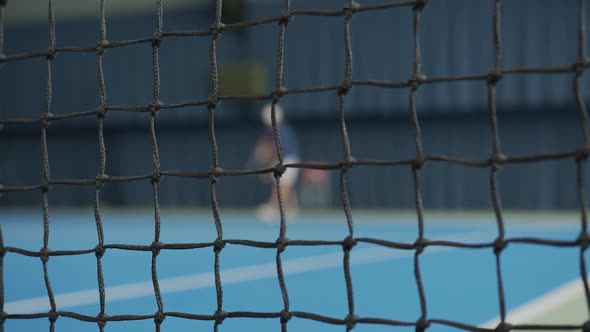 A Boy Tennis Player with a Tennis Racket in His Hands Strikes a Tennis Ball.