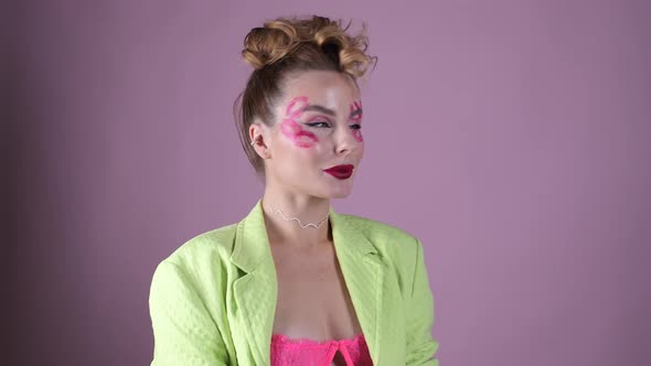 Young Beautiful Woman Professional Make Up Artist with Lipstick Marks Smile at Pink Background alt