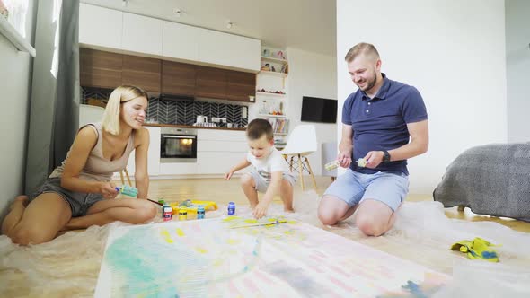 Joyful Family Surrounds Large Handmade Painting at Home