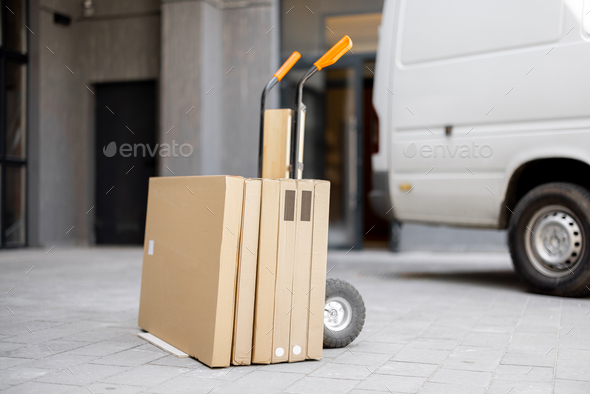 Order in cardboard boxes on a pushcart near building entrance
