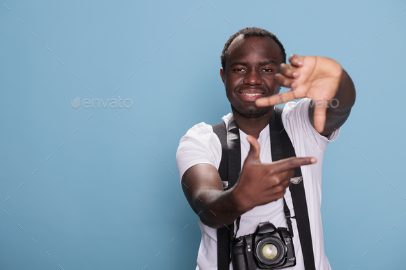 Happy african american photographer doing frame hand gesture with fingers