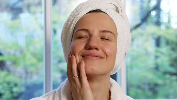 Positive Woman Gives Herself a Facial Massage 