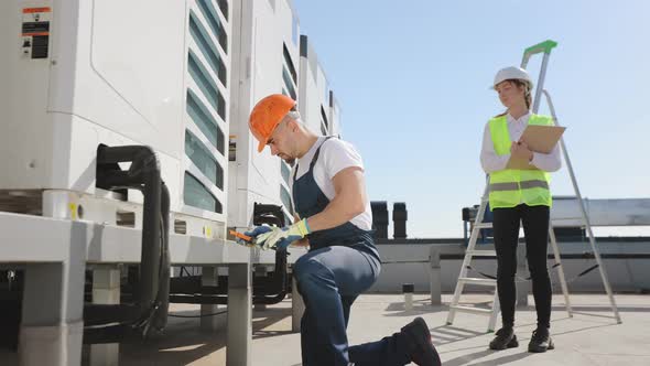 The Young Engineer is Maintaining the Air Conditioning System alt