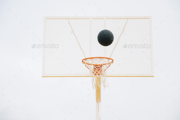 ball into basket in Outdoor basketball court and black ball Stock Photo