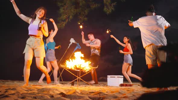 Group of Asian young man and woman having party on the beach at night. alt