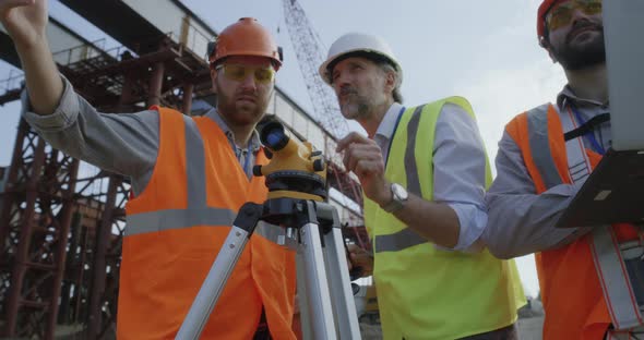 Surveyors Measuring Construction Site with Theodolite alt