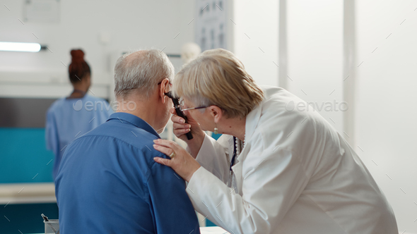 Otolaryngology specialist using otoscope to examine ear infection