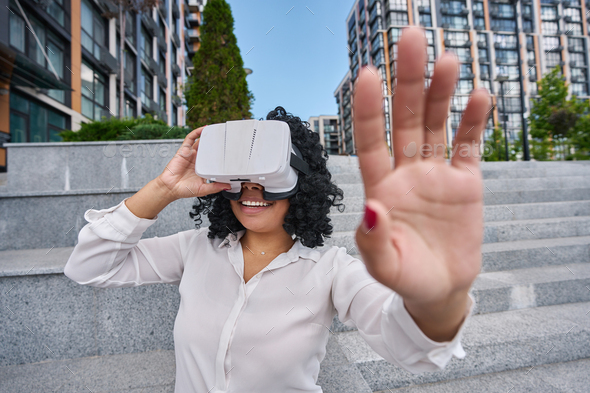 Woman walking around the city in virtual reality glasses