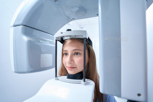 Calm young patient getting digital panoramic x-ray in clinic