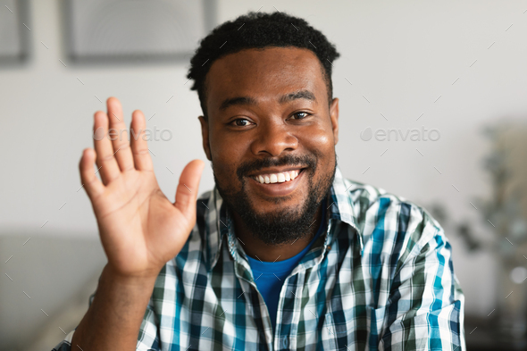 Cheerful African American Man Waving Hand Sitting Posing At Home