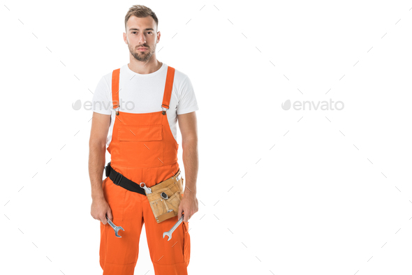 handsome auto mechanic in orange uniform holding wrenches isolated on white