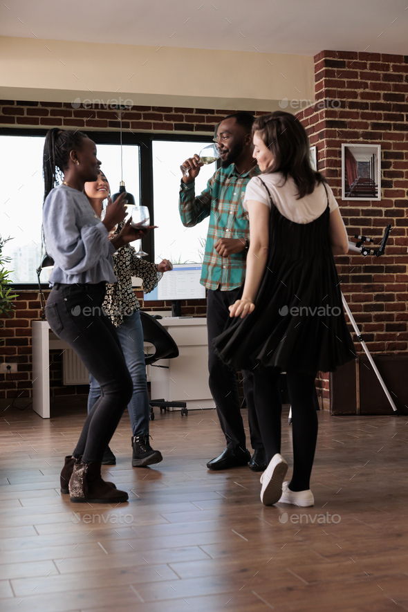 Multiethnic group of close friends dancing at party while celebrating important event