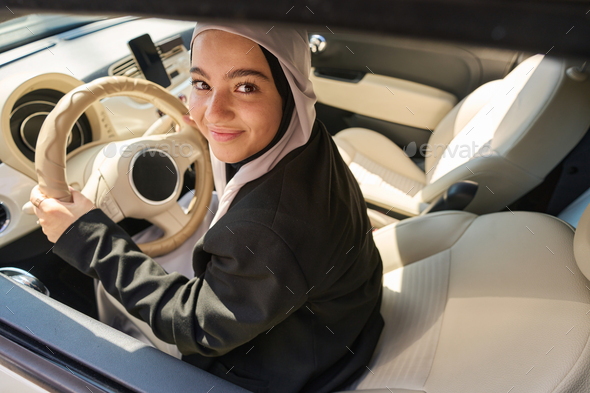 Arab woman driving a car with the driver\'s seat reclined