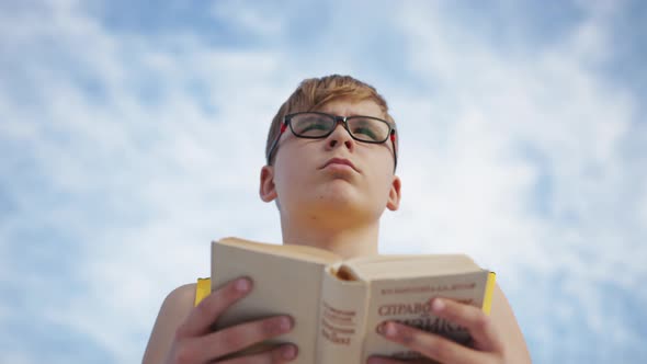 Young boy reading a book, slow motion alt