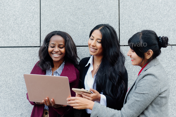 three cheerful multiracial business women