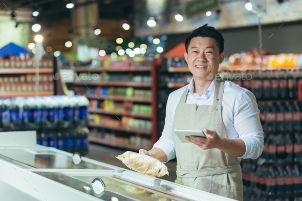 Portrait of Asian store manager, man with tablet checking expiration date of products