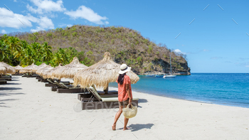 young woman walking on tropical beach at St lucia, girl on white beach with palm trees Caribbean