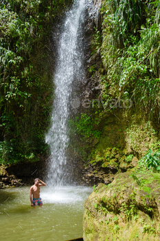 Young men relaxing at Toraille waterfall St Lucia. Saint Lucia jungle waterfall and men swimming