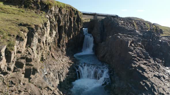 Ascending Shot of Water Cascade on Creek Flowing Through Narrow Ravine in Mountains alt