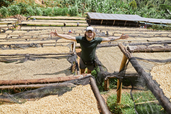 Happy guy in glasses staying at coffee washing station in Africa