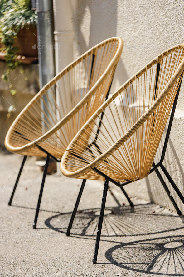 Cafe Furniture. Trendy Designer Chairs. Rattan Wicker Chair. Wicker Armchairs Stand Outside. Modern
