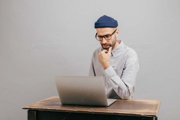 unshaven male owner of trading company searches information about marketing agency
