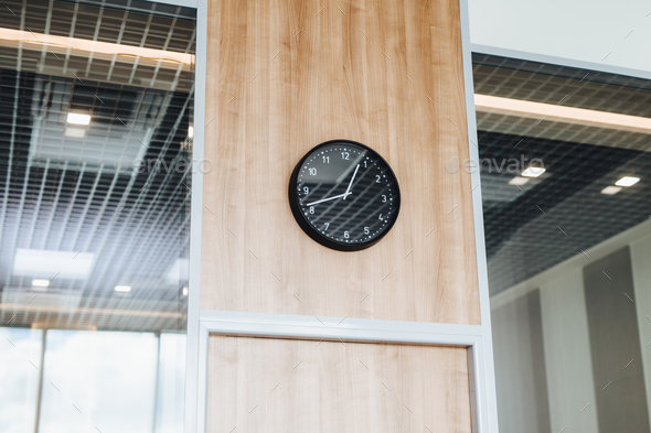 Round clock against office interior, symbolizes dinner break, no one at work