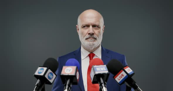 Politician feeling sad during his speech, he is touching his chest and being silent