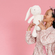 Asian girl wearing dress smiling while posing with stuffed bunny - PhotoDune Item for Sale