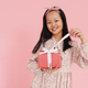 Asian girl wearing dress smiling while opening gift box - PhotoDune Item for Sale