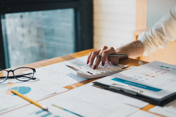 Close up a accountant working about financial with calculator at office to calculate expenses - Stock Photo - Images