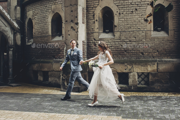 Beautiful emotional wedding couple running and smiling in european city. Provence wedding