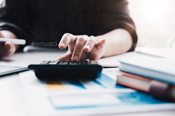 Close up Business woman using calculator and laptop for do math finance  - Stock Photo - Images