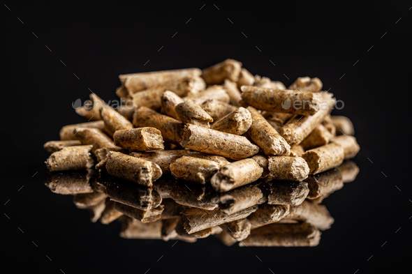 Wooden pellets on black background. Biomass - Renewable source of heating.