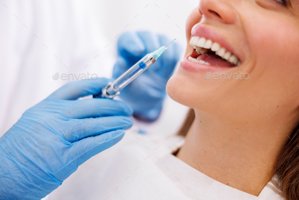 Dentist applying local anesthetic to patient