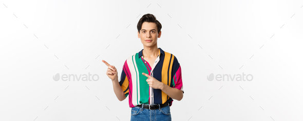 Image of stylish androgynous man smiling, pointing fingers left at logo, showing promo offer