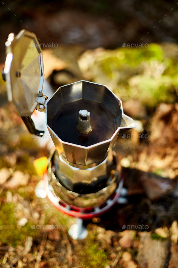 Making camping coffee from a geyser coffee maker on a gas burner