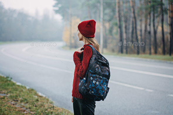 Sustainable tourism, responsible travel. Young woman traveler with backpack in pine forest