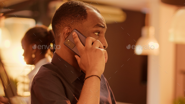 African american man talking on mobile phone call at office desk
