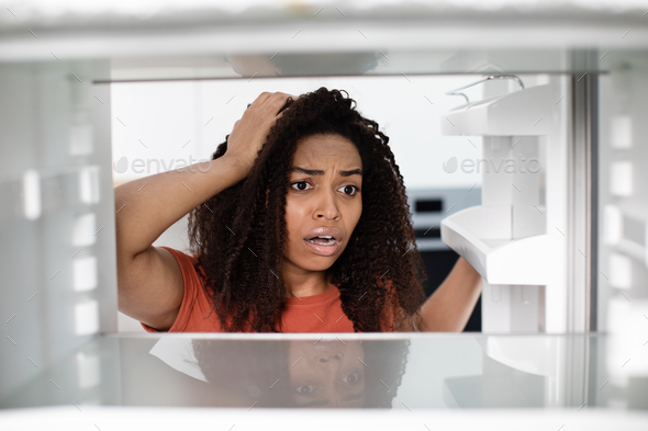 Hungry shocked disappointed pretty millennial african american woman with open mouth checks empty