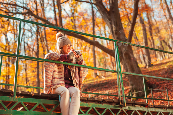 Woman photographing nature while spending sunny autumn day in the forest