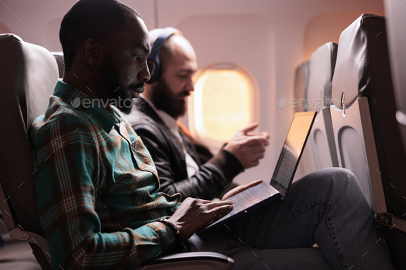 Businessman in seat travelling on work trip by airplane
