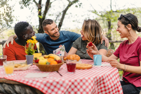 Group of cheerful multiethnic friends meets at brunch table