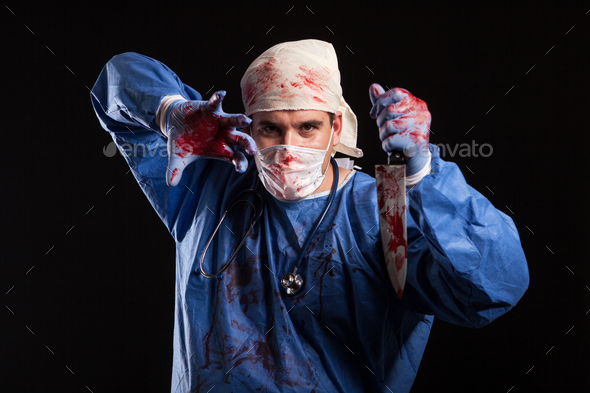 Doctor covered in blood with mask on his face for halloween in studio