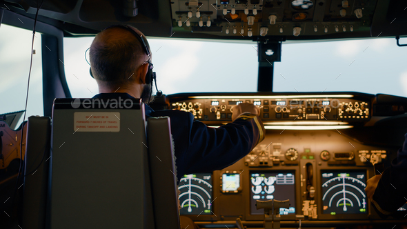 Male airline captain fixing altitude and longitude buttons