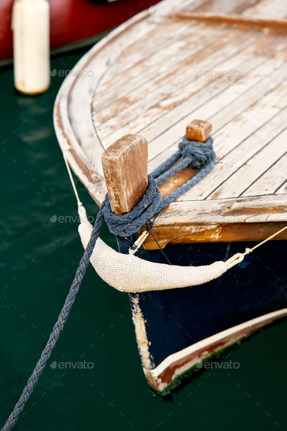Bow of a wooden boat with an anchor rope attached. Close-up Stock