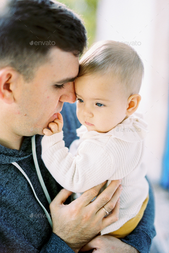 Baby touches dad face with his fingers. Portrait Stock Photo by Nadtochii